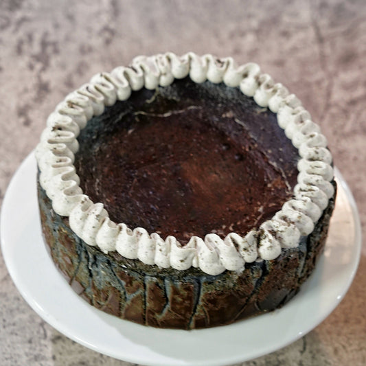 premium gluten-free Black Sesame Basque Cheesecake topped with a delicate ring of sesame cream, handcrafted by BLUEBUTTER Patisserie in Perth.