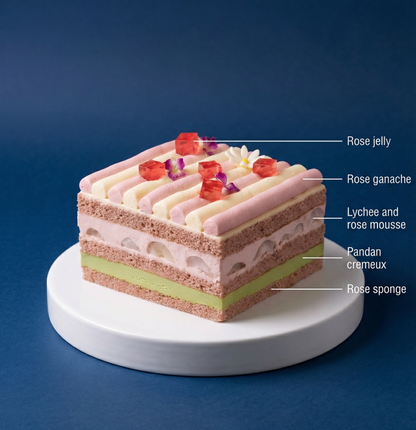 Cross-section showing layers of moist rose sponge, pandan cremeux, and lychee mousse in a French-style dessert.
